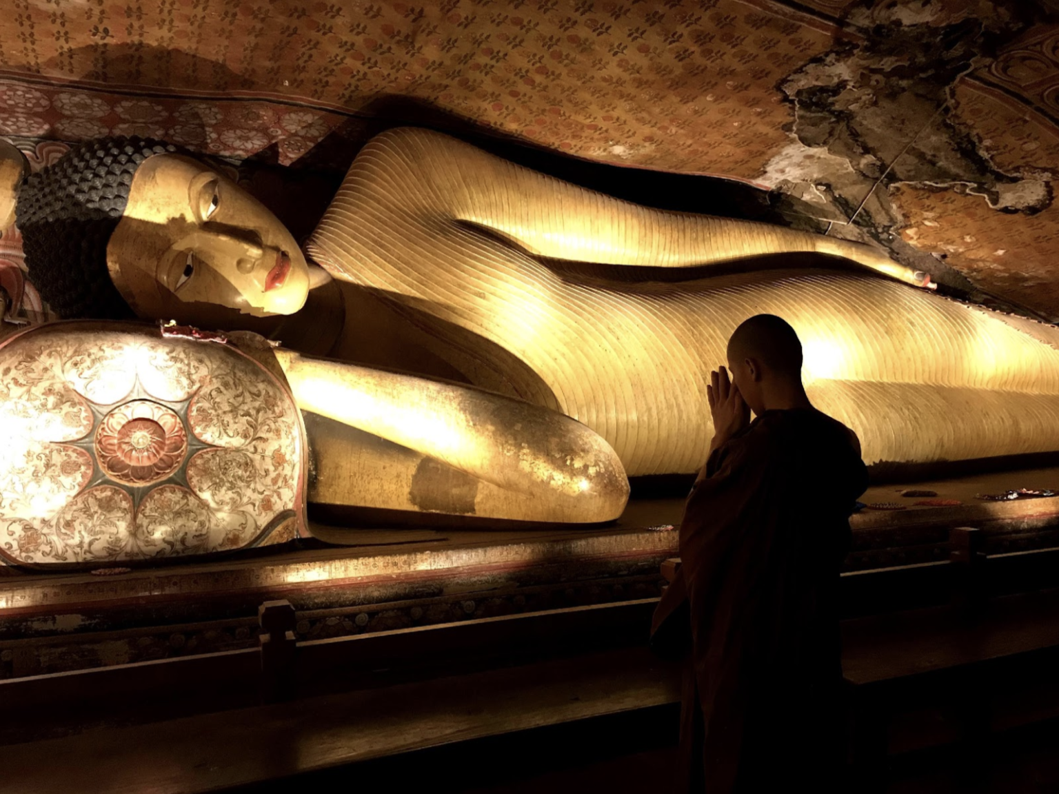Image of reclining buddha statue carved out of rock within a cave